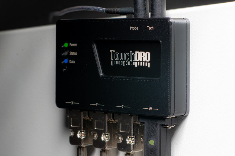 TouchDRO adapter box mounted to the side of a Bridgeport mill's ram, with scale cables routed to the machine's axes